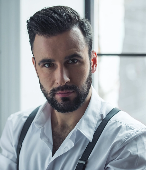 Hombre con barba y corte moderno de pelo.