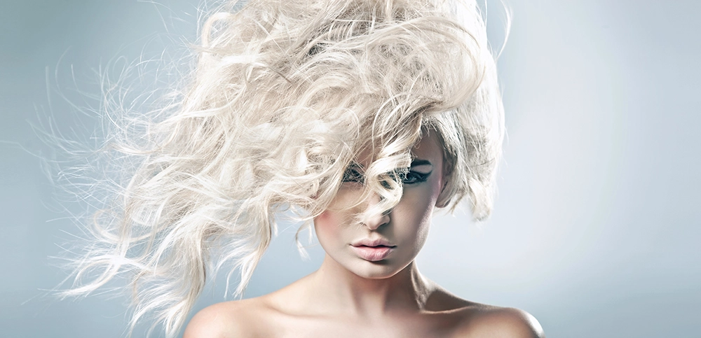 Modelo con melena rubia platino por delante de la cara.